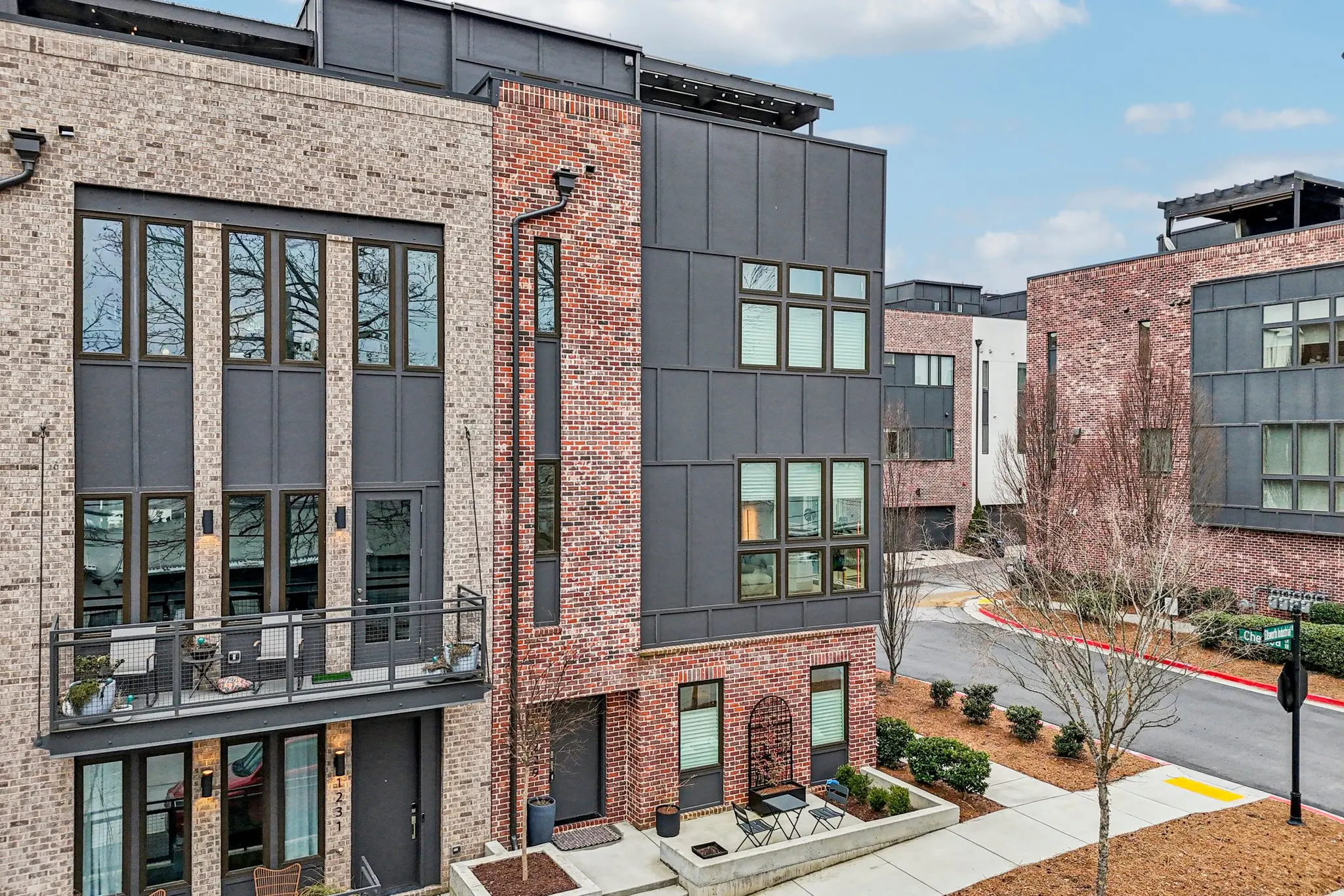 Chelsea Westside brick facades with black steel juliet balconies and an arched brick entry surround.